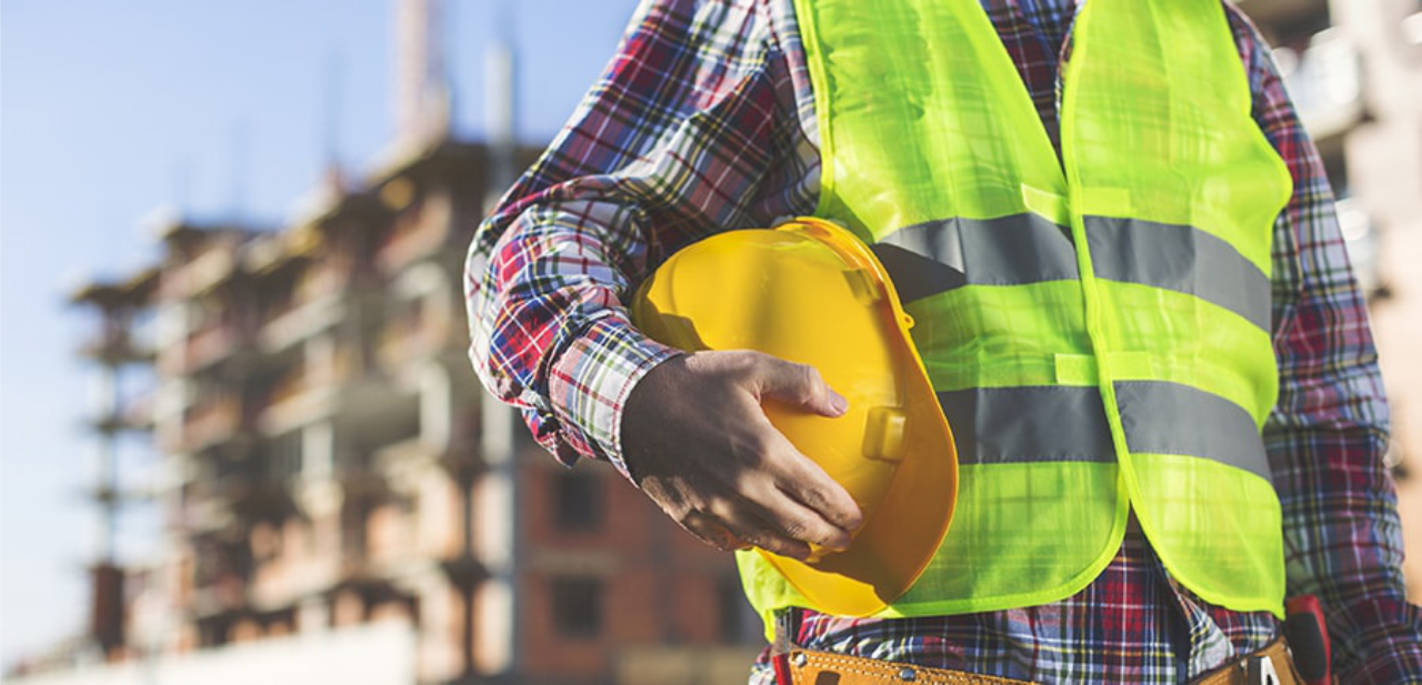 project manager with a helmet and high rise at the background